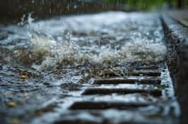 Close-up of stormwater drain with water gushing into it